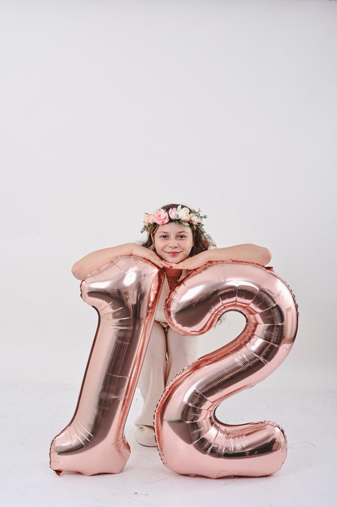 נערה עם בלונים בצורת המספר 12