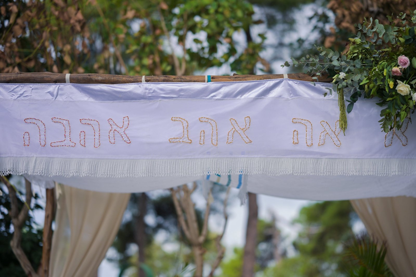 חופה מעוצבת עם הכתובת אהבה, פרחים וירק